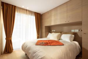 Un dormitorio con una cama con una bata naranja. en Campiglio WOOD en Madonna di Campiglio