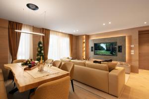 a living room with a dining table and a couch at Campiglio WOOD in Madonna di Campiglio