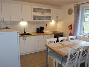 kuchnia z drewnianym stołem i białymi szafkami w obiekcie Holiday Home Holiday Hill 39 by Interhome w mieście Lauterwasser