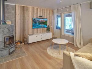 ein Wohnzimmer mit Couch und Kamin in der Unterkunft Holiday Home Iso-karpalo b by Interhome in Aikkila