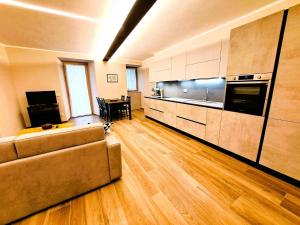 een woonkamer met een bank en een keuken bij Casa Alpina- Praetoria Suite in Aosta