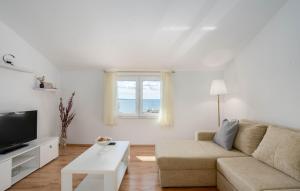 a white living room with a couch and a window at Villa Marante with heated private pool in Podstrana