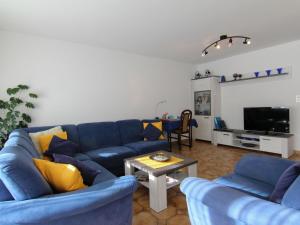 a living room with blue couches and a table at Apartment Casa Yolanda Mireille by Interhome in Fieschertal