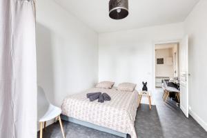 Un dormitorio con una cama con un osito de peluche. en Le Lilas Appart Hôtel Near Paris, en Vitry-sur-Seine