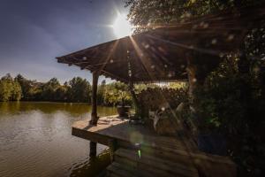 a wooden dock with an umbrella on a body of water at Silver Dollar in Watton
