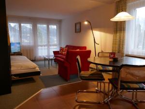 een woonkamer met een rode bank en een tafel bij Apartment Chalet Wyssefluh by Interhome in Grindelwald
