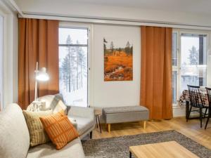 ein Wohnzimmer mit Sofa und Tisch in der Unterkunft Holiday Home Jymykatti by Interhome in Vuokatti