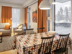 ein Esszimmer mit Tisch und Stühlen und ein Wohnzimmer in der Unterkunft Holiday Home Jymykatti by Interhome in Vuokatti