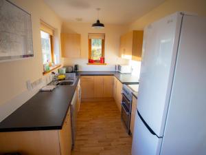a kitchen with a white refrigerator and a sink at Holiday Home Peter's Shed by Interhome in Drumnadrochit +93 photos