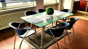a table with chairs and a green pineapple sitting on top at Ferienwohnung am Rauenhübel in Völklingen