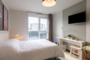 - une chambre avec un lit, un bureau et une fenêtre dans l'établissement Student Factory Le Havre Les Docks, au Havre