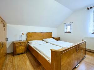 1 dormitorio con cama de madera y mesita de noche en Holiday Home Zlatá Olešnice 122 by Interhome en Zlatá Olešnice