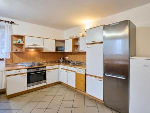uma cozinha com armários brancos e um frigorífico de aço inoxidável em Holiday Home Zlatá Olešnice 122 by Interhome em Zlatá Olešnice