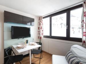 a small room with a desk and a bed and a tv at Studio Palafour - Le Lac-6 by Interhome in Tignes