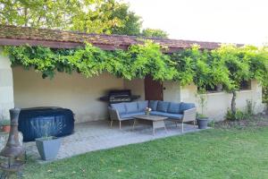 a patio with a couch and a table in a yard at Gîte avec piscine au cœur de la campagne 