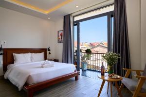 sypialnia z dużym łóżkiem i dużym oknem w obiekcie An Bang MQ Villa w Hoi An