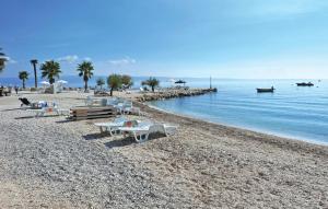 a beach with chairs and tables on a rocky beach at Villa Marante with heated private pool in Podstrana