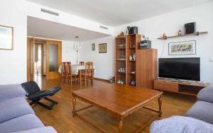 sala de estar con sofá, mesa y TV en Apartamento Ancora en primera línea de la playa, en Tossa de Mar