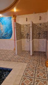 ein Bad mit Dusche und Mosaikboden in der Unterkunft Coliseum in Chmelnyzkyj