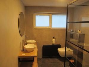 La salle de bains est pourvue de 2 lavabos, de toilettes et d'une fenêtre. dans l'établissement Gezellige, luxe bungalow 't pareltje in het bos in Hardenberg "Rheezerveen"woning 20, à Rheezerveen