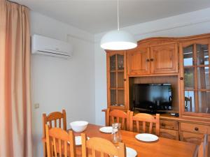 a dining room with a table and a tv at Villa Service - Rovior 3º 4ª in Calafell