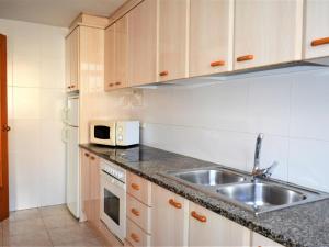 cocina con fregadero y microondas en Villa Service - Rovior 3º 4ª en Calafell