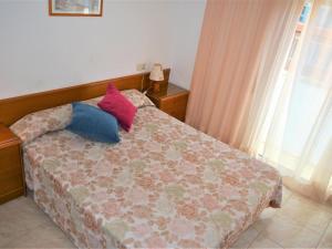 1 dormitorio con 1 cama con 2 almohadas en Villa Service - Rovior 3º 4ª, en Calafell