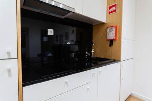una cucina con bancone, lavandino e specchio di Cozy apartment in the center of Porto a Porto
