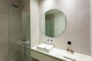 bagno con lavandino, specchio e doccia di Cozy apartment in the center of Porto a Porto