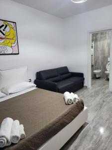 a bedroom with a bed and a black couch at Dimore Pietrapenta Apartments, Suites & Rooms - Via Lucana 223, Via Piave 23, Via Chiancalata 16 in Matera