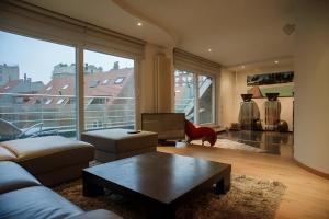 ein Wohnzimmer mit einem Sofa und einem großen Fenster in der Unterkunft Big and comfortable triplex in Knokke in Knokke-Heist