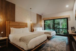 1 dormitorio con 2 camas y ventana grande en El Silencio Lodge & Spa Costa Rica, en Toro Amarillo
