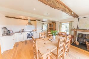 a kitchen and dining room with a wooden table at Hollin Bank Barn Coniston Water in Coniston