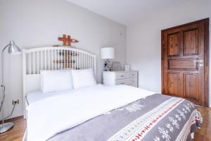 a bedroom with a white bed and a wooden door at Sleek Villa with Backyard and Sapanca Lake View in Sapanca