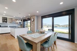 eine Küche und ein Esszimmer mit einem Holztisch und Stühlen in der Unterkunft Casa nueva con piscina y vistas al mar in Vilaboa