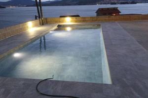 an empty swimming pool with a cord on the ground at Casa nueva con piscina y vistas al mar in Vilaboa