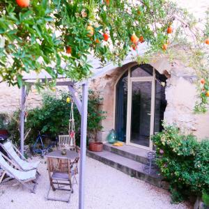 ein Haus mit einem Orangenbaum mit Stühlen und einer Veranda in der Unterkunft Entre Terre et Ciel in Mazan