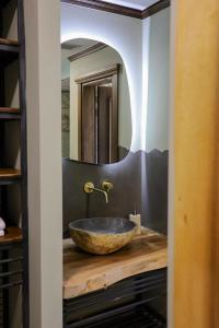 a bathroom with a stone sink and a mirror at Vila Strugu in Voskopojë