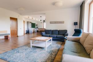 a living room with a couch and a table at Rose Hip Hill Guesthouse in Valea Tîrnei