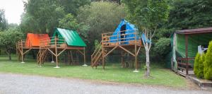 a group of three play structures in the grass at Camping Villaviciosa in La Rasa Selorio
