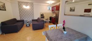 salon z kanapami i stołem oraz kuchnia w obiekcie Amulett Suite Apartment w Hajduszoboszlo