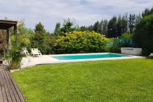 una piscina en medio de un patio en Hermosa casa con fogonero, parrilla cubierta, pileta y jardin parquizado en Benavídez