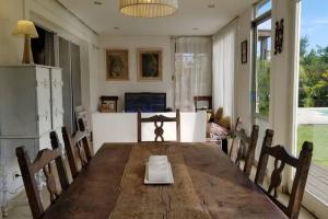 comedor con mesa de madera y sillas en Hermosa casa con fogonero, parrilla cubierta, pileta y jardin parquizado en Benavídez
