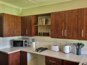 a kitchen with wooden cabinets and a counter top at The Crofters Cottage in Underberg