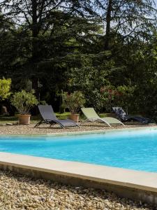 a group of chairs sitting next to a swimming pool at Chambres d'hôtes Les Baumes in Saint-Quentin-la-Poterie