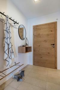 Habitación con puerta de madera y espejo. en Haus Sonnbichl, en Weissensee