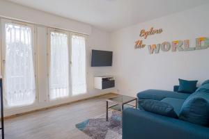 a living room with a blue couch and a tv at LeRouget : Hypercentre / Jardin aménagé / Hamak in Moissy-Cramayel