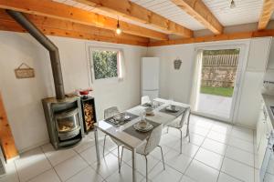 a dining room with a table and a wood stove at Joli duplex avec piscine in Cournillens