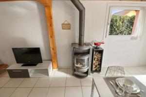 a kitchen with a stove and a television in it at Joli duplex avec piscine in Cournillens