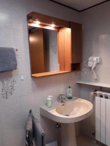 ein Bad mit einem Waschbecken und einem Spiegel in der Unterkunft Casa Martina "holiday home" Marano Lagunare in Marano Lagunare